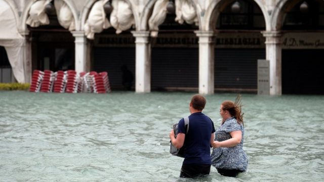 Couple walk in flooded St Mark Square in Venice on 29 October 2018