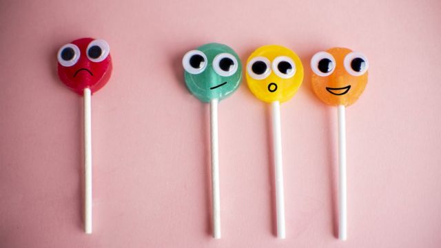 Pirulitos coloridos com carinhas que representam diferentes expressões