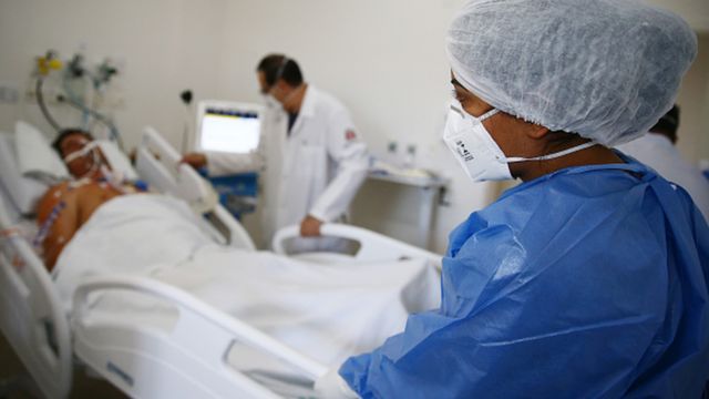 Un paciente conectado a un respirador en una cama de hospital
