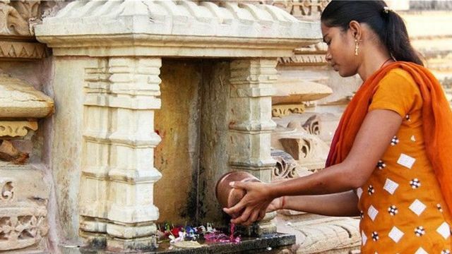 एक तरुणी पूजा करताना