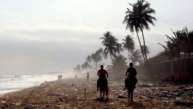 People ride horses on a beach in Abidjan, Ivory Coast - Wednesday July 2021