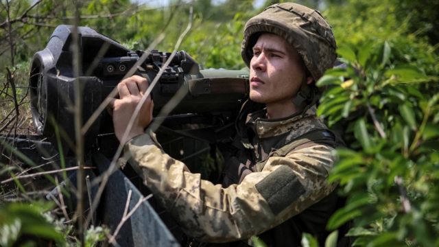 Ukraiński członek służby trzyma lekką broń przeciwpancerną nowej generacji (NLAW)
