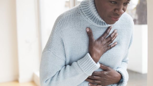 A woman holding on to her chest in pain