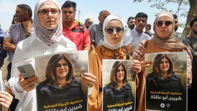 Palestinians hold up posters showing Shireen Abu Aqla, who was killed during an Israeli raid in the occupied West Bank city of Jenin (11 May 2022)