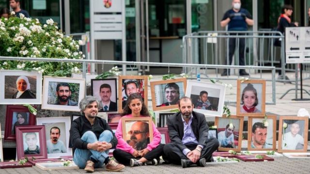 عرض نشطاء مناهضون للأسد صورا للضحايا خارج المحكمة