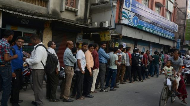 असम के सिलिगुड़ी में पैसे के लिए एटीएम के बाहर खड़े लोग.