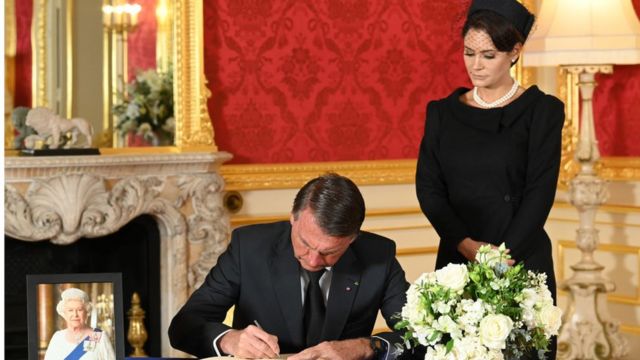 Jair Bolsonaro (PL), ao lado da primeira-dama Michelle Bolsonaro, assina o livro de condolências pela morte da rainha Elizabeth 2ª, em Londres