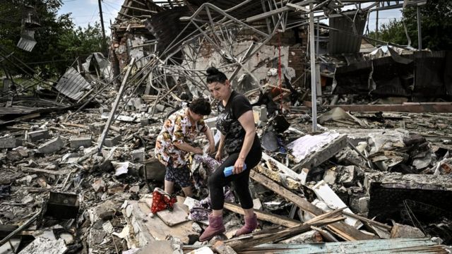 Ukrayna'nın Donbas bölgesinde bir Rus saldırısının ardından evlerinin yıkıntısında eşyalarını arayan siviller