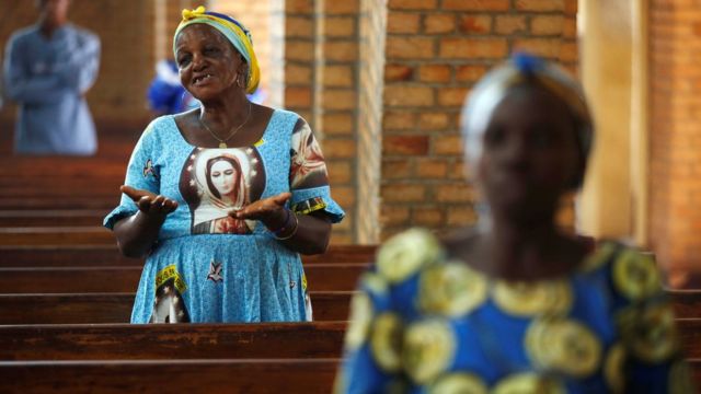 A woman prays during a mass for a peaceful elections at the Notre Dame de Kinshasa cathedra