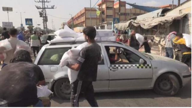 Pessoas carregando suprimentos em Gaza