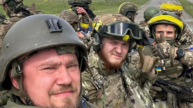 Membros do Corpo de Voluntários Russos posam para uma foto em cima de um veículo blindado na fronteira de Graivoron, em Kozinka, na região de Belgorod, na Rússia, em 23 de maio de 2023