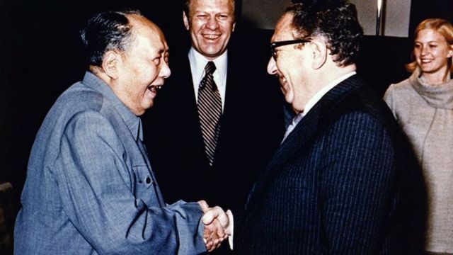 सन् १९७५ डिसेम्बरमा अमेरिकी राष्ट्रपति जेराल्ड फोर्डले (बीचमा) आफ्ना विदेशमन्त्री हेनरी किसिन्जरसहित चीन भ्रमण गरेका थिए। तस्बिरमा माओसँग किसिन्जरले हात मिलाइरहेको देखिन्छ