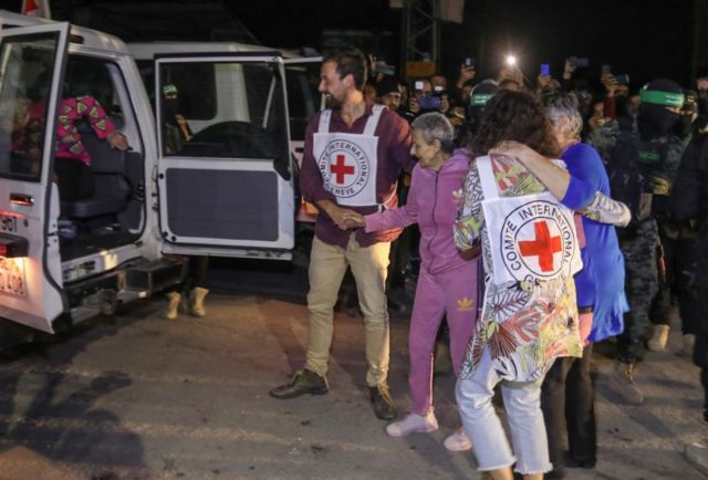 Una anciana es ayudada a subir a un vehículo de la Cruz Roja tras ser entregada por Hamás