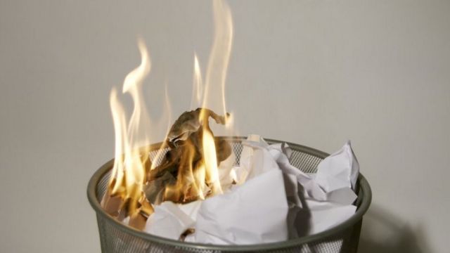 Una papepelera en la que arden papeles