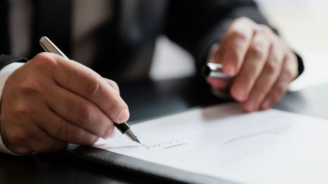 Stock image of a man signing a contract