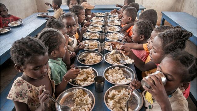Schoolchildren from Ankileisoke Primary School eat lunch, offered by the World Food Programme's Under-nutrition Prevention Programme, in the Amboasary-South district of southern Madagascar, on December 14, 2018.