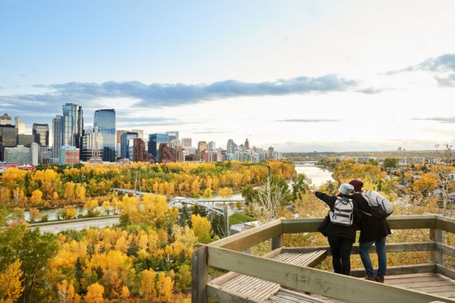Una pareja viendo Calgary desde el mirador de un parque.