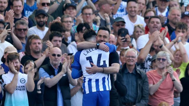 Brighton & Hove Albion's Adam Lallana is hugged by manager Roberto De Zerbi