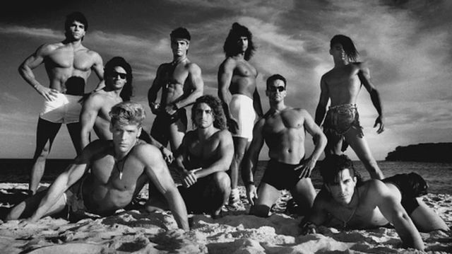 Naked men on a beach.