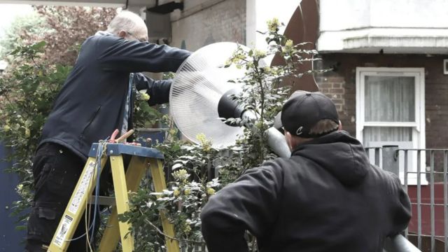 Homem instalando estrutura de iluminação em casa