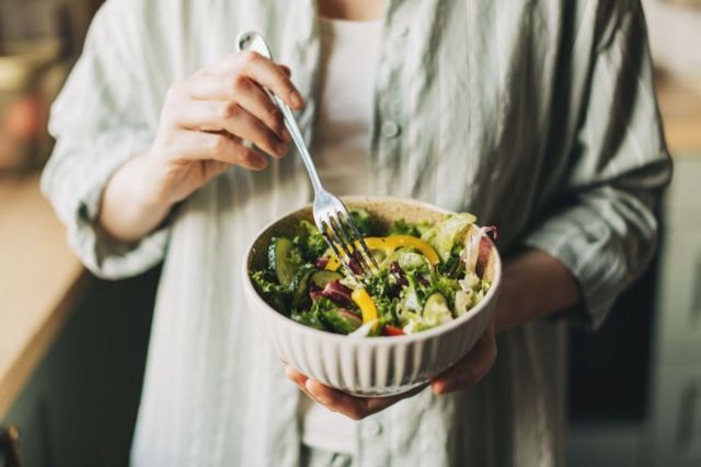 Uma pessoa come salada