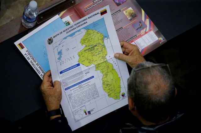 Parlamentar de costas segura e observa mapa