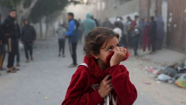 Una niña se tapa la nariz con su abrigo