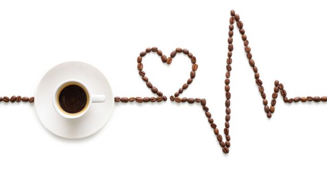 Xícara de café ao lado de grãos de café em ordem como um eletrocardiograma