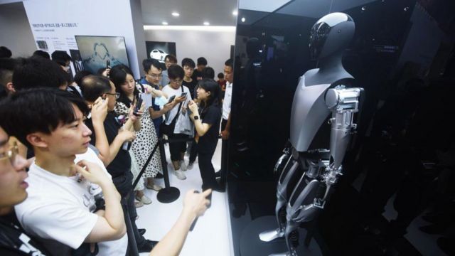 Visitantes conferem o robô humanoide Optimus da Tesla, exposto na Conferência Mundial de Inteligência Artificial em Xangai, na China