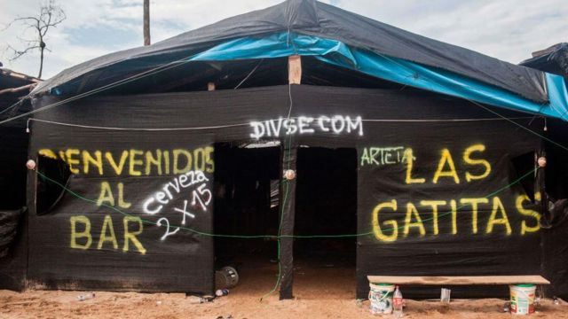 La puerta de un bar hecho de palos y plástico