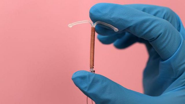 DIU segurado em mão com luvas