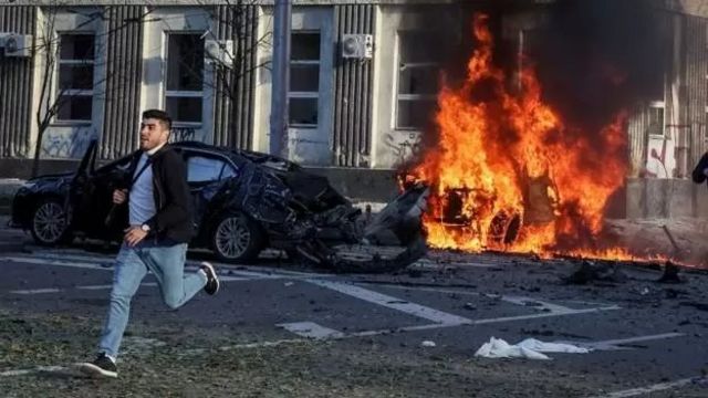 Một người đàn ông chạy khỏi chiếc xe đang bốc cháy sau khi một tên lửa đánh trúng trung tâm Kyiv sáng 10/10