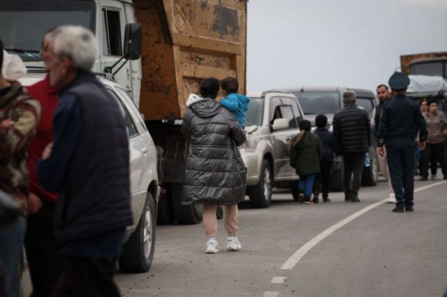Los refugiados esperando después de cruzar la frontera y llegar a un centro de registro del Ministerio de Asuntos Exteriores de Armenia, cerca de la ciudad fronteriza de Kornidzor.