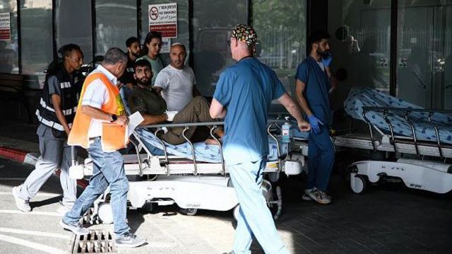 Médicos empurram um homem ferido na entrada de emergência do hospital Ichilov, em Tel Aviv, após uma incursão do Hamas nos assentamentos israelenses ao redor da Faixa de Gaza