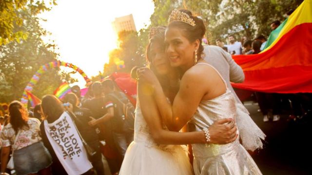 Dos mujeres queer vestidas de novia se abrazan