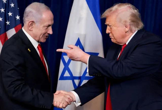 Reuters Benjamin Netanyahu and Donald Trump shake hands while standing in front of US and Israeli flags