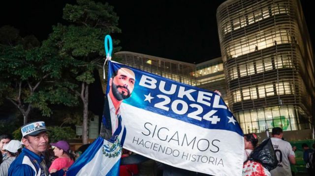 Simpatizante de Bukele con una bandera con su imagen alusiva a las elecciones de febrero de 2024 frente a la Biblioteca Nacional, en San Salvador, en noviembrede 2023.