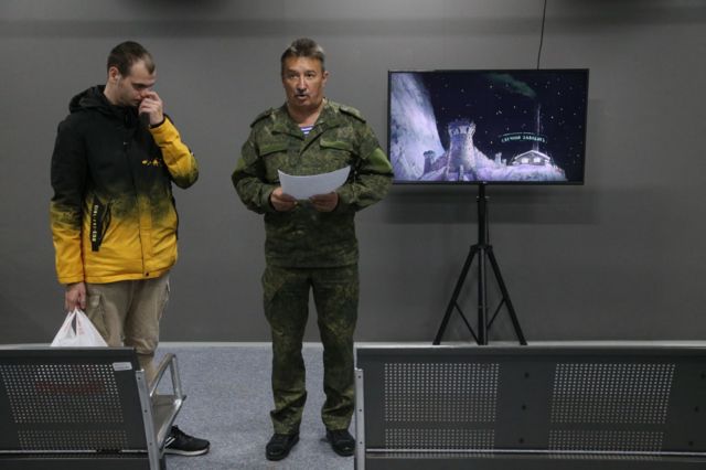 In Moscow, a senior is seen making an announcement at the recruiting center.