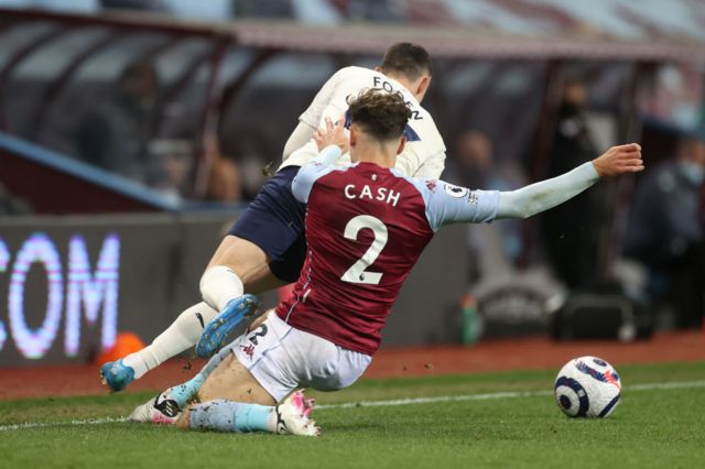 Matty Cash hauls down Manchester City midfielder Phil Foden