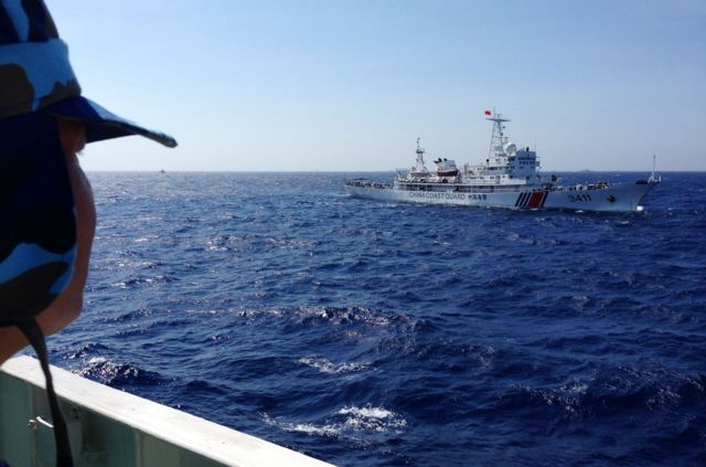 Một thành viên Cảnh sát biển Việt Nam (bìa trái) đang theo dõi tàu Hải cảnh Trung Quốc gần quần đảo Hoàng Sa khi căng thẳng dâng cao vào năm 2014