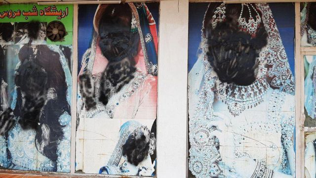 Imagens de mulheres na vitrine de salão de beleza com os rostos pintados de preto
