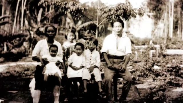 Família japonesa em fazenda, com mata ao fundo