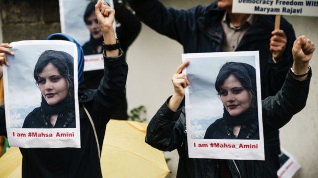 Protesters hold up picutres of Mahsa Amnini in Berlin, Germany