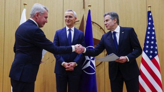NATO-nun baş katibi Jens Stoltenberg Finlandiyanın xarici işlər naziri Pekka Haavisto və ABŞ dövlət katibi Antony Blinken-in əl sıxmalarını izləyir