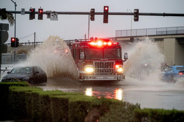 Un camión de bomberos del condado de Riverside atraviesa el agua de la inundación durante la tormenta tropical Hilary en Coachella, California.