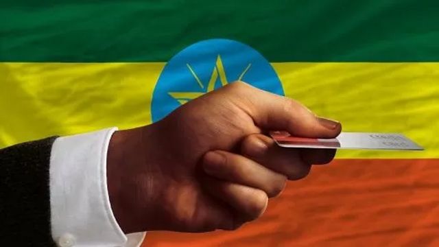 ናይ ባንክ ካርድ ዝሓዘ ሰብ ምስ ባንዴራ ኢትዮጵያ