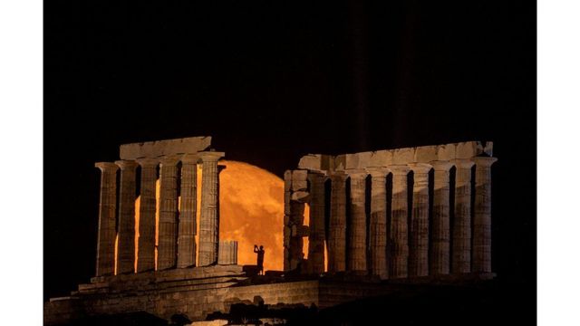 La luna llena saliendo detrás del Templo de Poseidón en Cabo Sounion, cerca de Atena