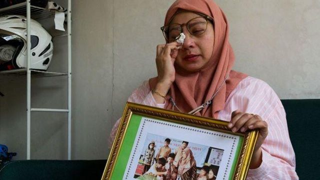 Safitri Puspa Rani memegang bingkai foto mendiang putranya Panghegar Bhumi sambil menangis saat menjelaskan kondisi putranya sebelum meninggal.