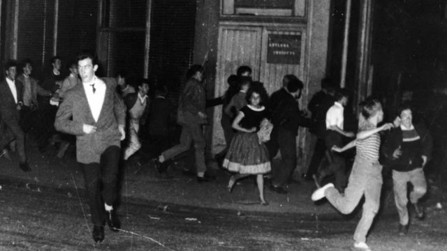 Pessoas correndo em Notting Hill, em 1958