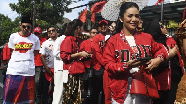 Kader PDI Perjuangan Krisdayanti (kanan) mengikuti pawai budaya menuju Gedung KPU untuk pengajuan bakal calon anggota DPR di Jakarta, Kamis (11/5/2023).